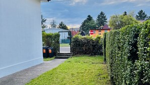 A residential area with a pathway leading to a gated entrance, surrounded by greenery and houses. - Beautiful & Lovely Stay | Prime Spot by Belvedere (Vienna)