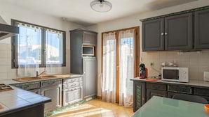 Una cocina con pileta, estufa, microondas y alacenas.