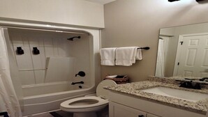A bathroom with a bathtub, toilet, sink, and a mirror. - 3BR Basement Apartment Close to CU (Central)