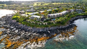An aerial view of a coastal resort with multiple buildings, a rocky shoreline, and clear waters. - Napili Point | Oceanfront 3 BR, Sleeps 8 | Car Incl. w/ 6+ Nights | NAP ML-1556 by KBM (Lahaina)