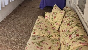 A room with a bed, a small table, and a sofa.