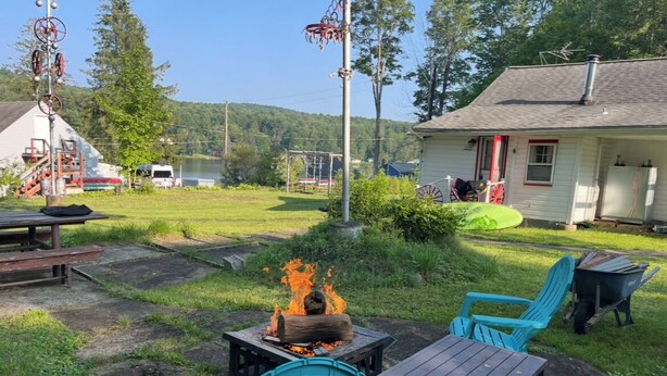 An outdoor seating area with a fire pit, chairs, and a table.