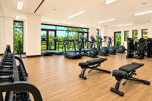 A gym with treadmills, elliptical machines, and weightlifting equipment.
