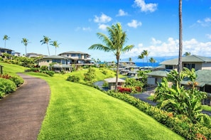 A resort with multiple-story buildings, a paved pathway, and lush greenery.
