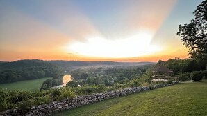 Un muro de piedra, una zona cubierta de césped y un río.