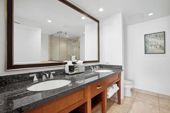 A bathroom with two sinks, a large mirror, and a toilet.