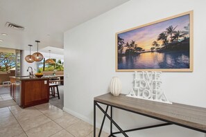A modern kitchen with a wooden island, pendant lights, and a view of the outdoors.