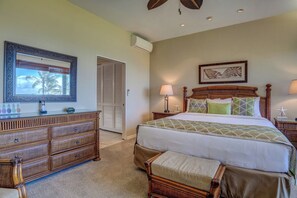 A bedroom with a bed, dresser, bedside tables, and a window.