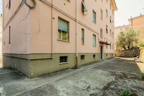 Ein Gebäude mit einer flachen Fassade, zahlreichen Fenstern und einem gepflasterten Innenhof.
