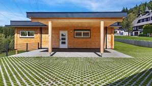 Una casa moderna de madera con techo plano, puerta principal y ventanas.