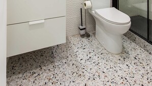 A modern bathroom with a white vanity, a round mirror, a toilet, and a glass-enclosed shower. - Cosy Studio - 2P - Exhibition Center / Tour Eiffel (Paris)
