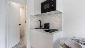 A compact kitchen with a built-in microwave, a coffee maker, and a sink. - Cosy Studio - 2P - Exhibition Center / Tour Eiffel (Paris)