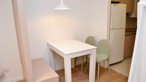 A small, clean room with a white table, two chairs, a white lamp, and a white refrigerator. - Buenos Aires: Palermo. Perfect for digital nomads. (Buenos Aires)
