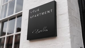 Une plaque noire sur un mur blanc portant l’inscription : « VOTRE APPARTEMENT, Hotwells ».