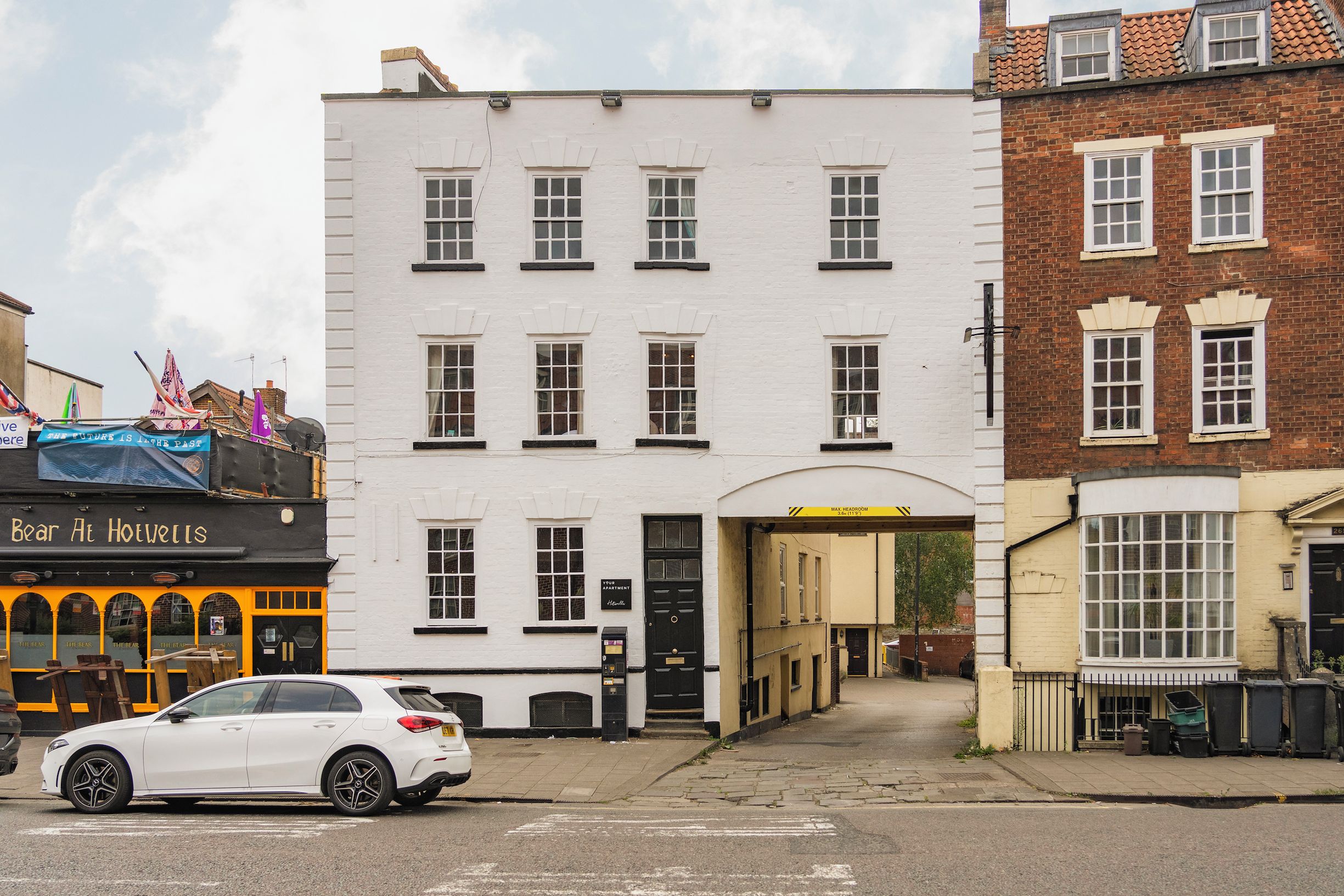 A white building with multiple windows and a black door.