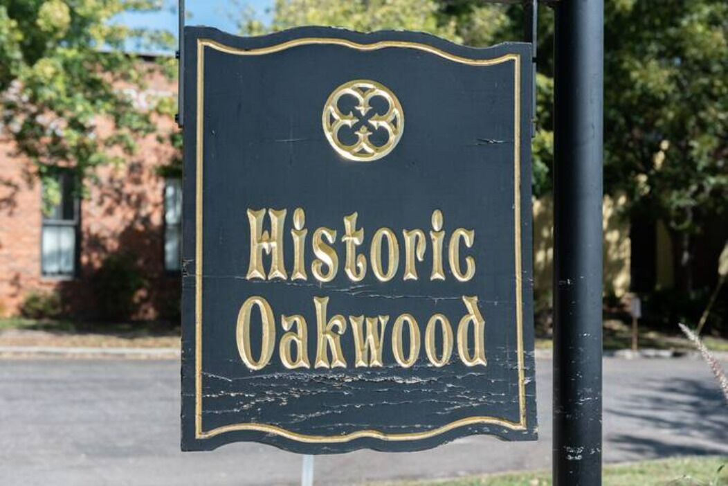 A sign with the text "Historic Oakwood" and a decorative emblem.