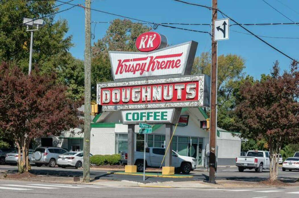 Una tienda Krispy Kreme con un letrero que anuncia rosquillas y café.
