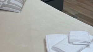 A neatly made bed with a pillow and folded towels, a bedside lamp, and a nightstand. - Accommodation located 26 km from Milan, 9.9 km from Como and 15 km from Switzerland. (Manera)