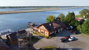 A house with a dock, a boat, and a parking area with cars. - Studio for 4 People in Swinoujscie (Swinoujscie)