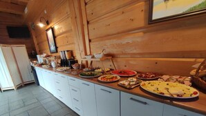 A buffet setup with various dishes on a counter, a refrigerator, and a tiled floor. - Studio for 4 People in Swinoujscie (Swinoujscie)