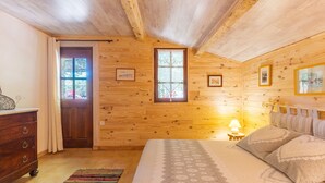 A wooden cabin bedroom with a bed, dresser, and two windows. - Holiday Home 'Bastide Provençale' with Private Pool, Private Terrace and Private Garden (Caseneuve)