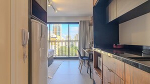 A modern kitchen with a dining area and a large balcony with city views. - Urbic Sabiá (São Paulo)