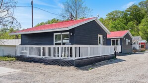 A single-story building with a red roof, a covered porch, and a gravel driveway.