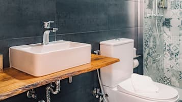 Een moderne badkamer met een rechthoekig wastafelmeubel, toilet en douchecabine.