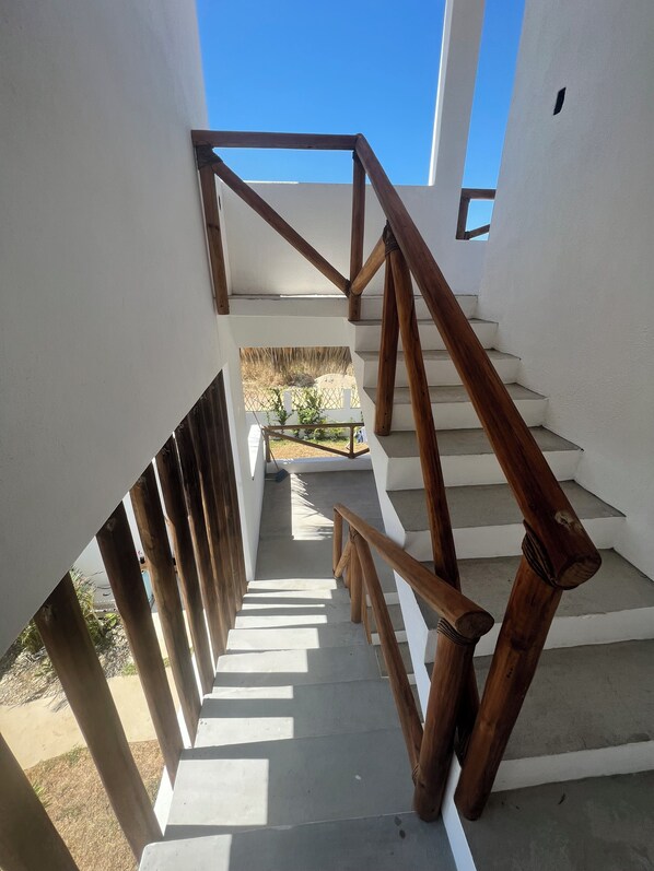 A staircase with wooden railings and white walls. - Peaceful Beach House in Oaxaca-Surrounded by Nature, Pool, Family & Pet Friendly (Agua Blanca)