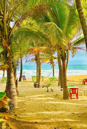 A beach with palm trees, a sandy shore, and a few beach chairs. - Peaceful Beach House in Oaxaca-Surrounded by Nature, Pool, Family & Pet Friendly (Agua Blanca)
