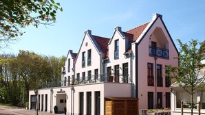 A modern two-story residential building with a symmetrical facade, large windows, and a red-tiled roof. - "Relaxed vacation days await you in the apartment Sergio 1 on Norderney!" (Norderney)