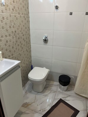 A bathroom with a toilet, a sink, and a trash bin. - Tha flat 311 (Campinas)