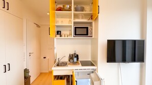 A compact kitchen with a microwave, sink, and a small countertop. - Bümmerstede (Oldenburg)