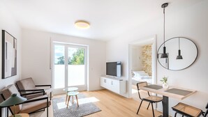 Una sala moderna con un sofá, una mesa de comedor y un televisor.