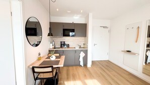 Una cocina moderna con comedor, espejo y piso de madera.