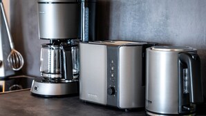 A kitchen with a coffee maker, toaster, and electric kettle.