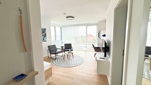 A modern living room with a sofa, chairs, a coffee table, and a TV. - Drielake (Oldenburg)