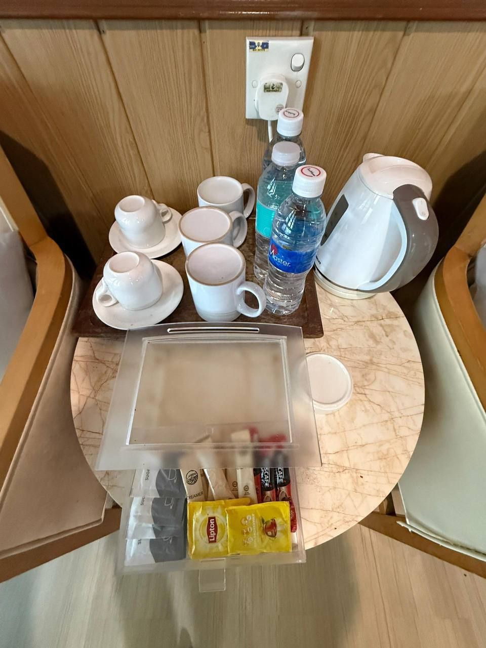 A compact kitchenette with a coffee maker, a water bottle, and a microwave.