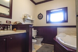 Un bagno con WC, lavandino, vasca e una finestra.