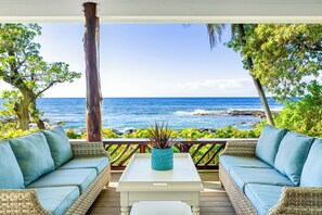 A covered outdoor seating area with wicker furniture and a view of the ocean. - Ocean Front House. 3100 SF, 4 bd/4bath. Huge Lani. Marine life galore. Sunsets. (Waimea)