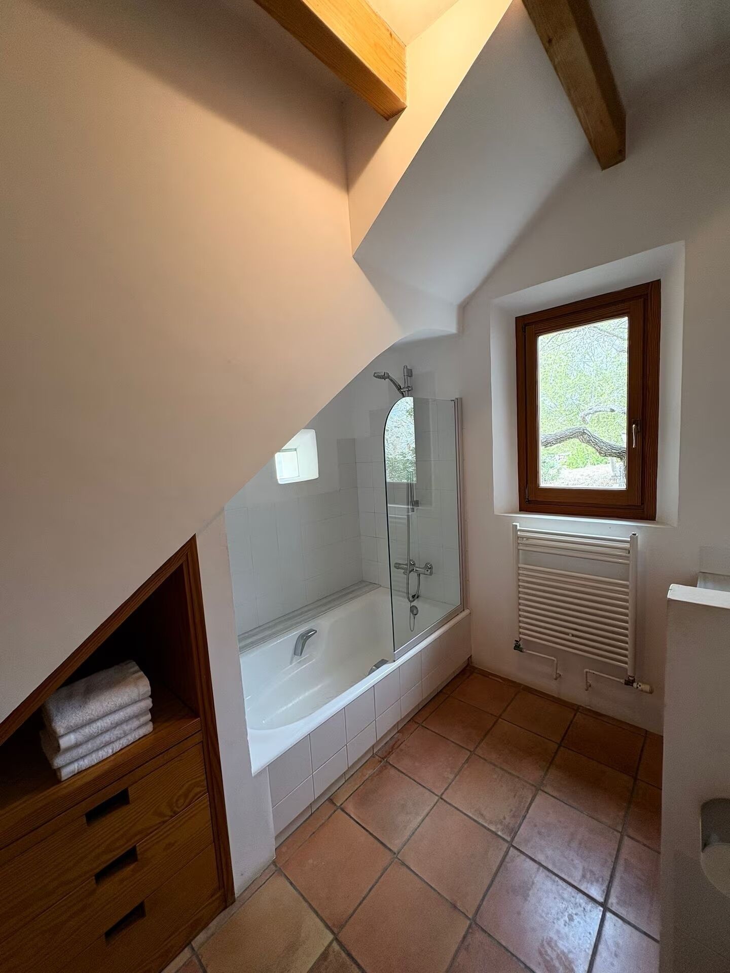 Une salle de bain avec une baignoire, une douche et une fenêtre.