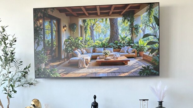 A modern living room with a large flat-screen TV mounted on the wall, a glass coffee table, and a wooden herringbone-patterned cabinet below. - Cityscape Escape/Art District Vibes/Bay & City Views (San Juan)