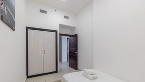 Ein Schlafzimmer mit einem Bett, einem Kleiderschrank und einer Tür zu einem anderen Raum.
