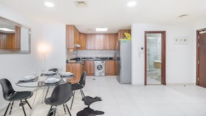 Een moderne keuken met houten kastjes, een roestvrijstalen koelkast en een wasmachine.