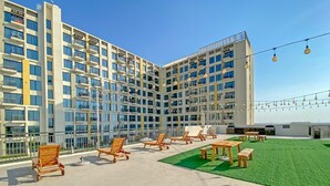 Un hôtel moderne à plusieurs étages, doté d’espaces extérieurs aménagés et d’un jardin sur le toit.