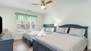 A bedroom with two beds, a ceiling fan, a desk, and a window with curtains. - NEW Surfside Beach 2 BR 1 BA Unit with Hot Tub minutes to private beach access (Murrells Inlet)