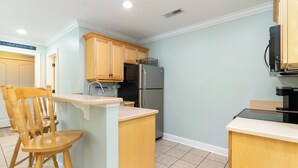 A kitchen with wooden cabinets, a stainless steel refrigerator, and a wooden island with a sink. - NEW Surfside Beach 2 BR 1 BA Unit with Hot Tub minutes to private beach access (Murrells Inlet)
