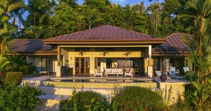 Un complexe hôtelier doté d’une piscine, d’un patio couvert et d’un environnement tropical luxuriant.