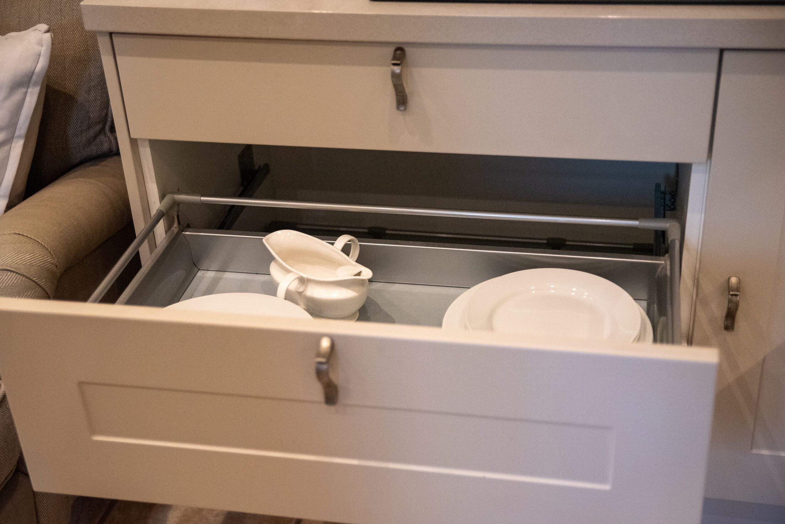 Un meuble à tiroirs blanc contenant une assiette et une tasse.