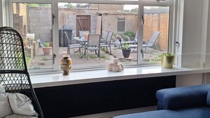 A room with a large window overlooking a backyard patio area.